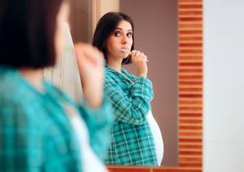 pregnant woman brushing teeth